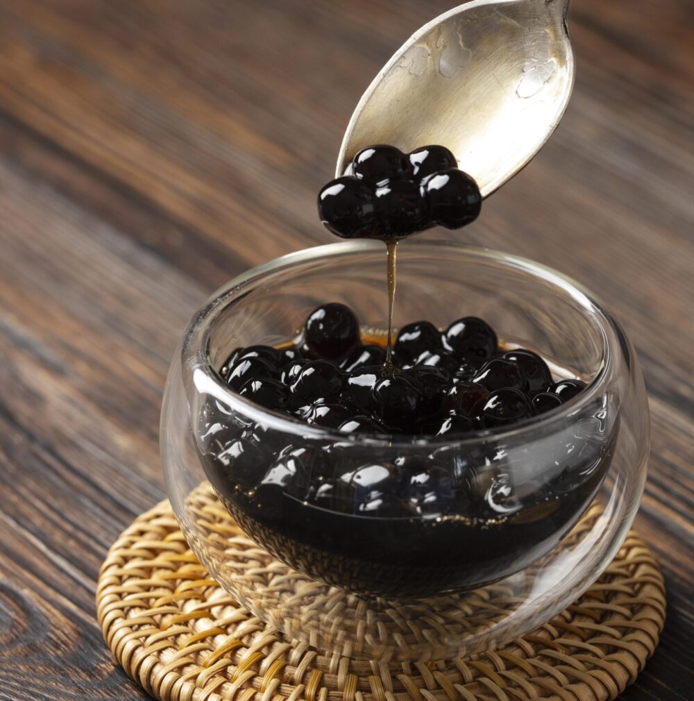 Close-up of chewy tapioca pearls submerged in a glass of refreshing bubble tea.